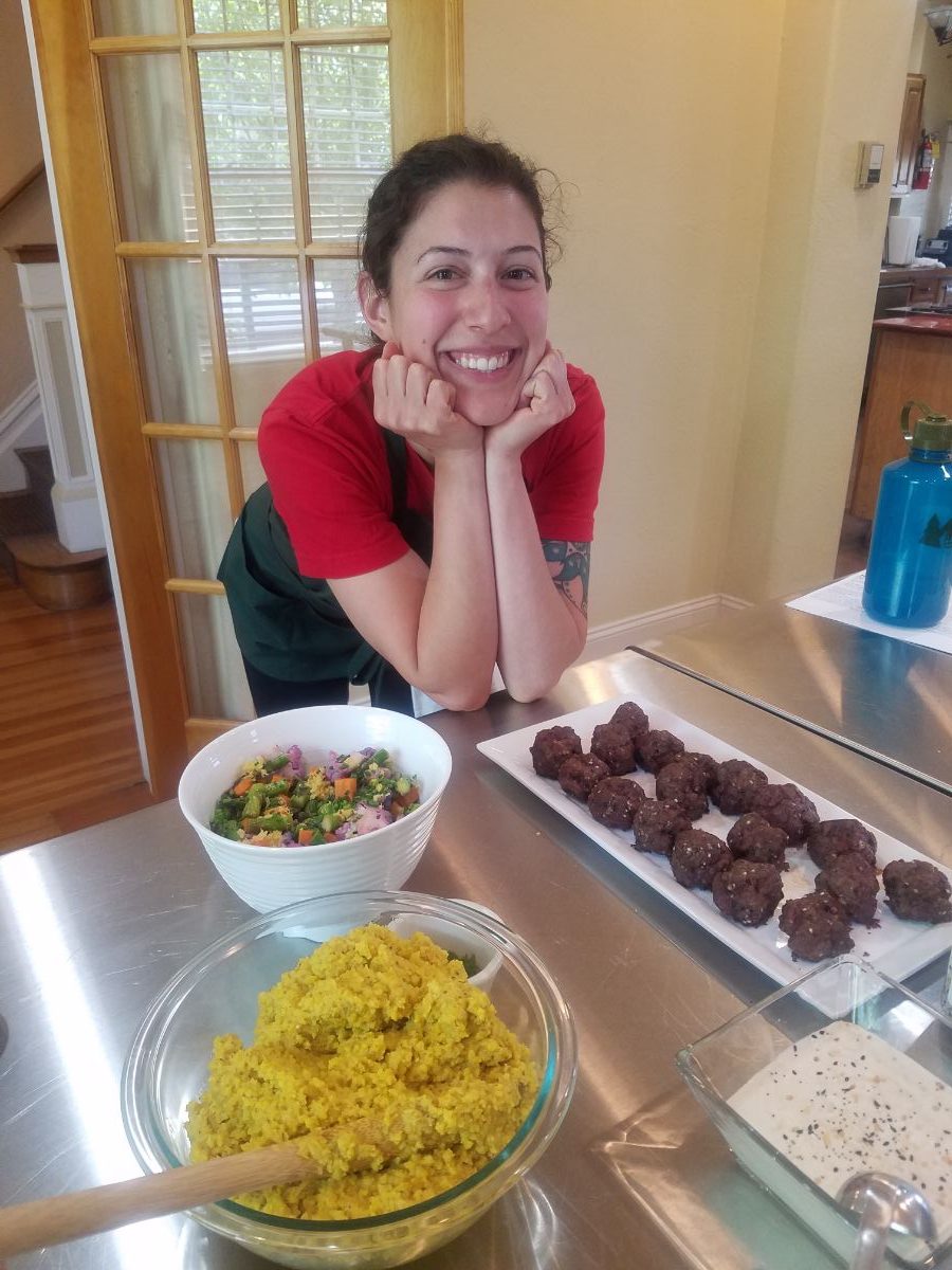 Jessica Eggleston in a kitchen in front of a salad and a plate of brownies